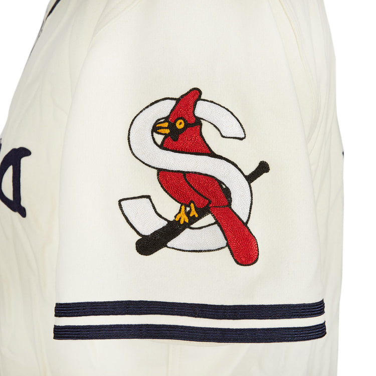 A close-up of the EFF Sacramento Solons 1940 Home Jersey sleeve shows a red cardinal on a black bat, with a large white S in the background and two navy stripes near the cuff.