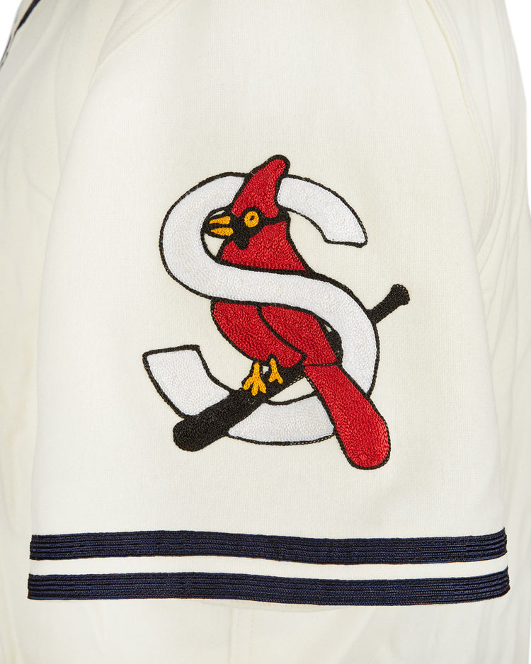 A close-up of the EFF Sacramento Solons 1940 Home Jersey sleeve shows a red cardinal on a black bat, with a large white S in the background and two navy stripes near the cuff.