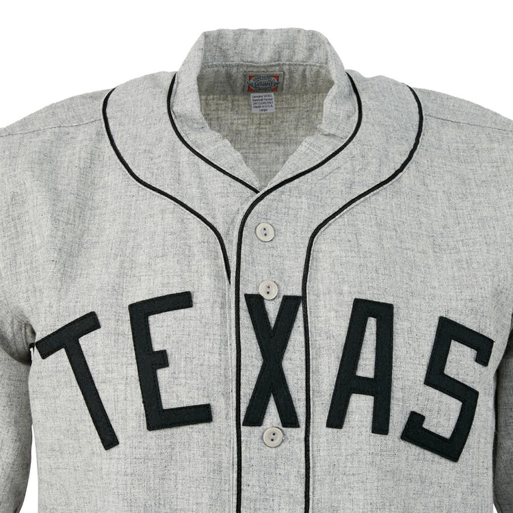 The EFF Texas Black Spiders 1938 Road Jersey is a gray vintage-style baseball jersey with black piping, large TEXAS lettering, a collar, and four white front buttons—an authentic tribute to the legendary barnstorming team.