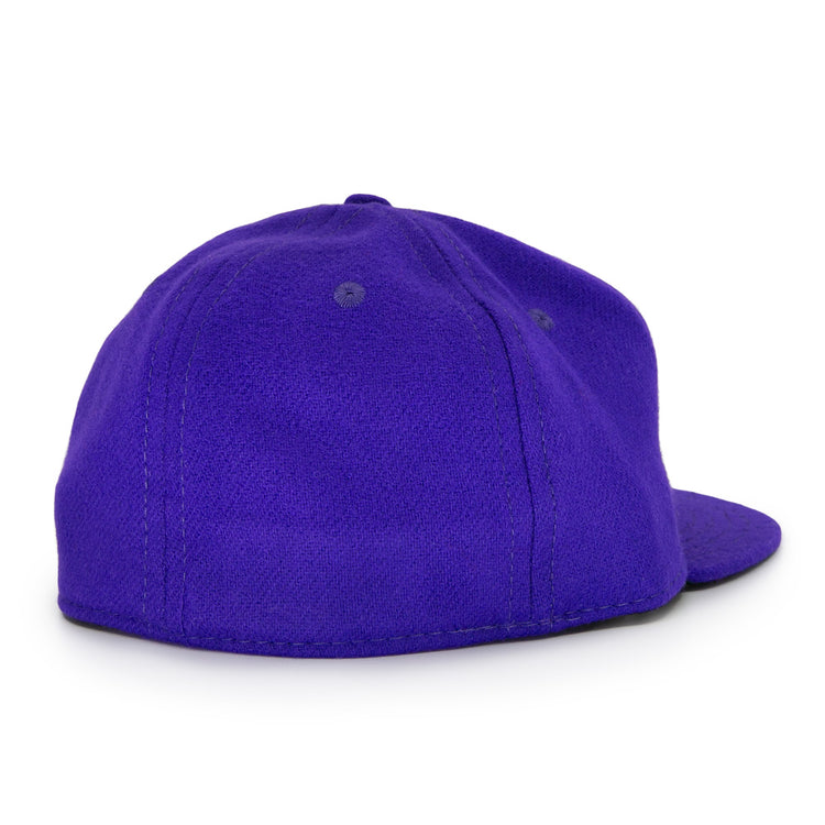 The Ebbets Field Flannels Club Teléfonos 1943 Vintage Ballcap is shown from the back, revealing its plain purple wool design with a flat brim and two stitched eyelets on top, without any visible logos or designs.