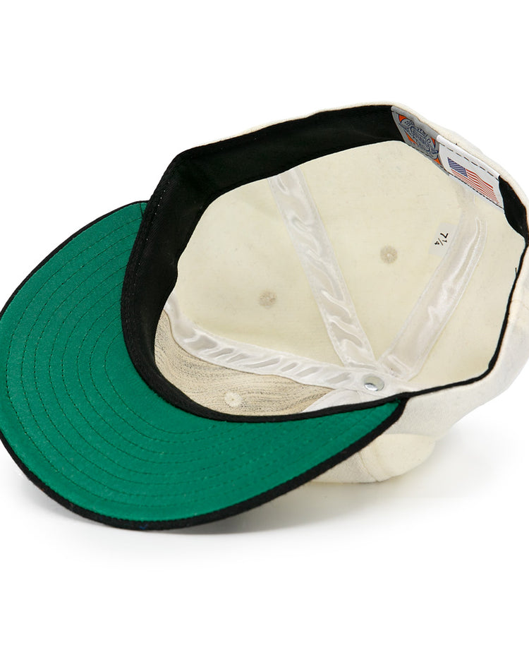 The Tokyo Kyojin (Giants) 1948 Vintage Ballcap by Ebbets Field Flannels is shown upside down, revealing a green brim underside, black inner band, white panels, and an inside American flag tag.