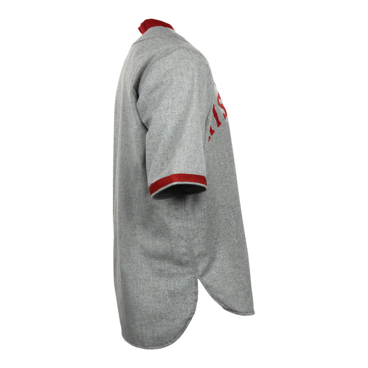 Side view of the EFF University of Wisconsin 1930 Road Jersey, a vintage gray baseball jersey with red collar and sleeve trim, textured fabric, curved hem, and partially visible red front lettering.