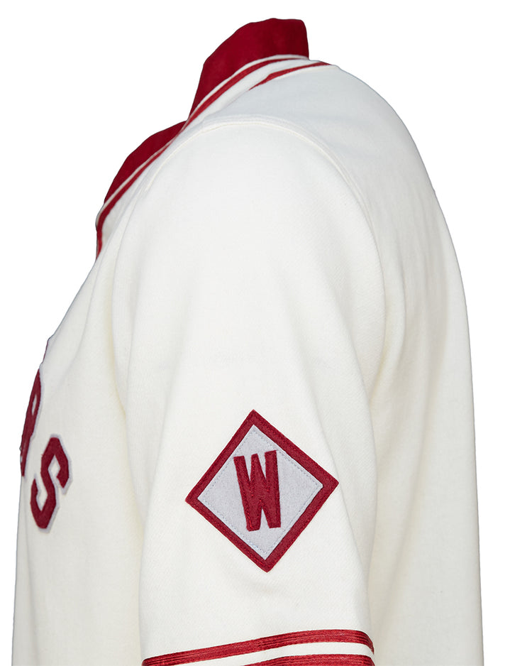 A close-up side view of the EFF Washington State University 1937 Home Jersey, showcasing white fabric with red accents, a red diamond patch with a white W on the sleeve, and classic red lettering authentic to WSU.