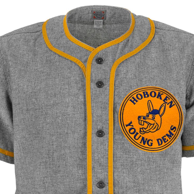 The EFF Hoboken Young Democrats 1972 Road Jersey is a gray vintage baseball jersey with yellow trim, black buttons, and a large yellow chest patch featuring Hoboken Young Dems and a blue donkey—ideal for Little League history fans.