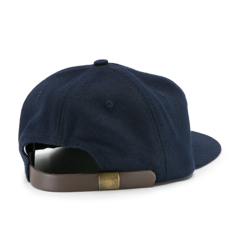 The Howard University 1960 Vintage Ballcap by EFF is shown from the back, displaying its navy blue design and an adjustable brown leather strap with a brass buckle.