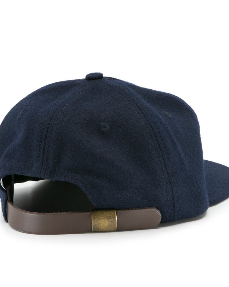 The Howard University 1960 Vintage Ballcap by EFF is shown from the back, displaying its navy blue design and an adjustable brown leather strap with a brass buckle.