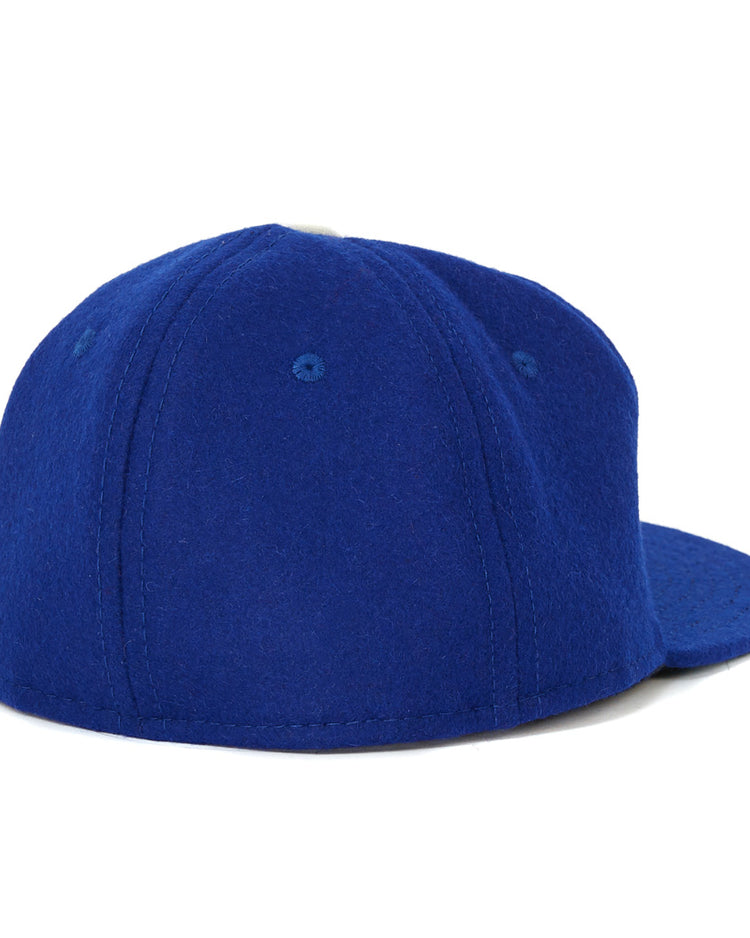 The EFF Oakland Oaks 1950 Vintage Ballcap is shown from the back left, featuring plain royal blue fabric, visible stitching, and ventilation holes. It channels classic Pacific Coast League style with no logos or designs visible.