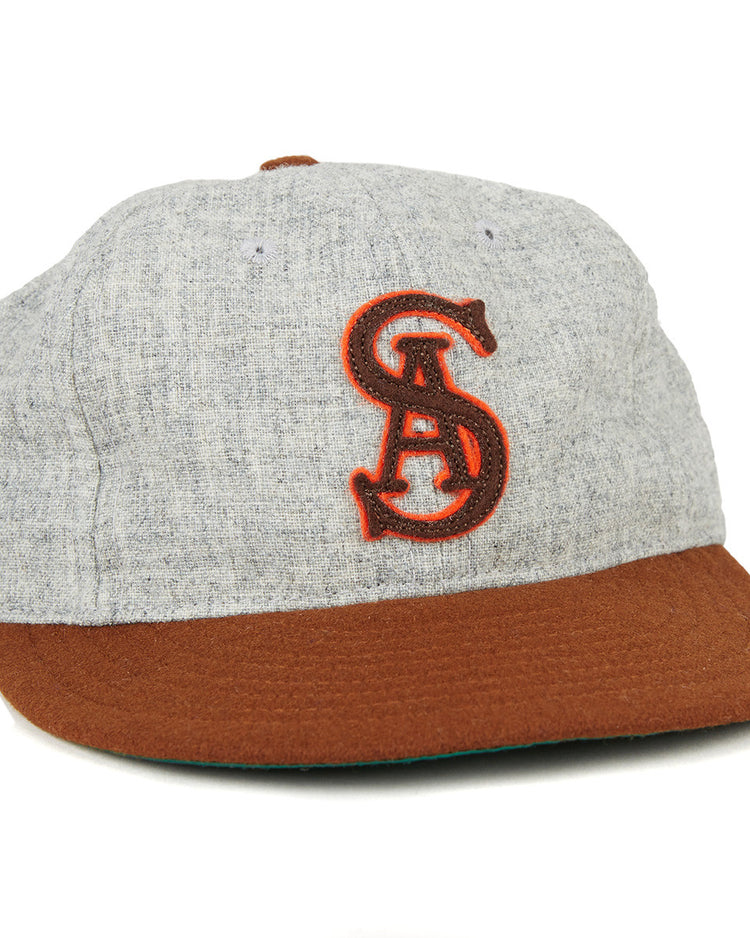 The EFF San Antonio Missions 1938 Vintage Ballcap features a gray crown, brown brim, and an authentic red embroidered intertwined SA logo, echoing the classic teams original style.